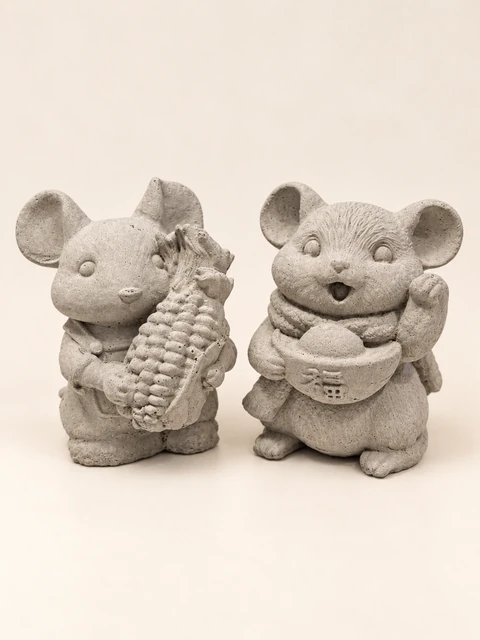 Two mouse figures in concrete colour, one with a corn cob and the other with a scarf, a bowl form and a raised paw