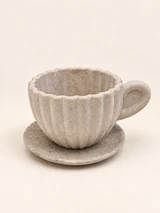Light ribbed decorative cup with a wavy rim, a cast handle and a saucer, from another angle