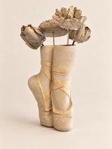 Light ballet shoe vase with gold ribbons and four different flower forms on slender stems. Main view.