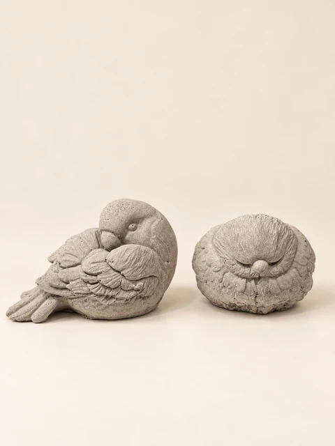 Two bird figures in concrete colour, a bird with a curved neck and a rounded sleeping bird figure