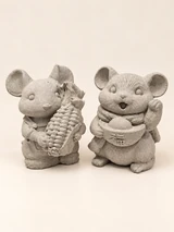 Two mouse figures in concrete colour, one with a corn cob and the other with a scarf, a bowl form and a raised paw