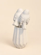 Back of two light birds on slender stakes in a light, angular vase